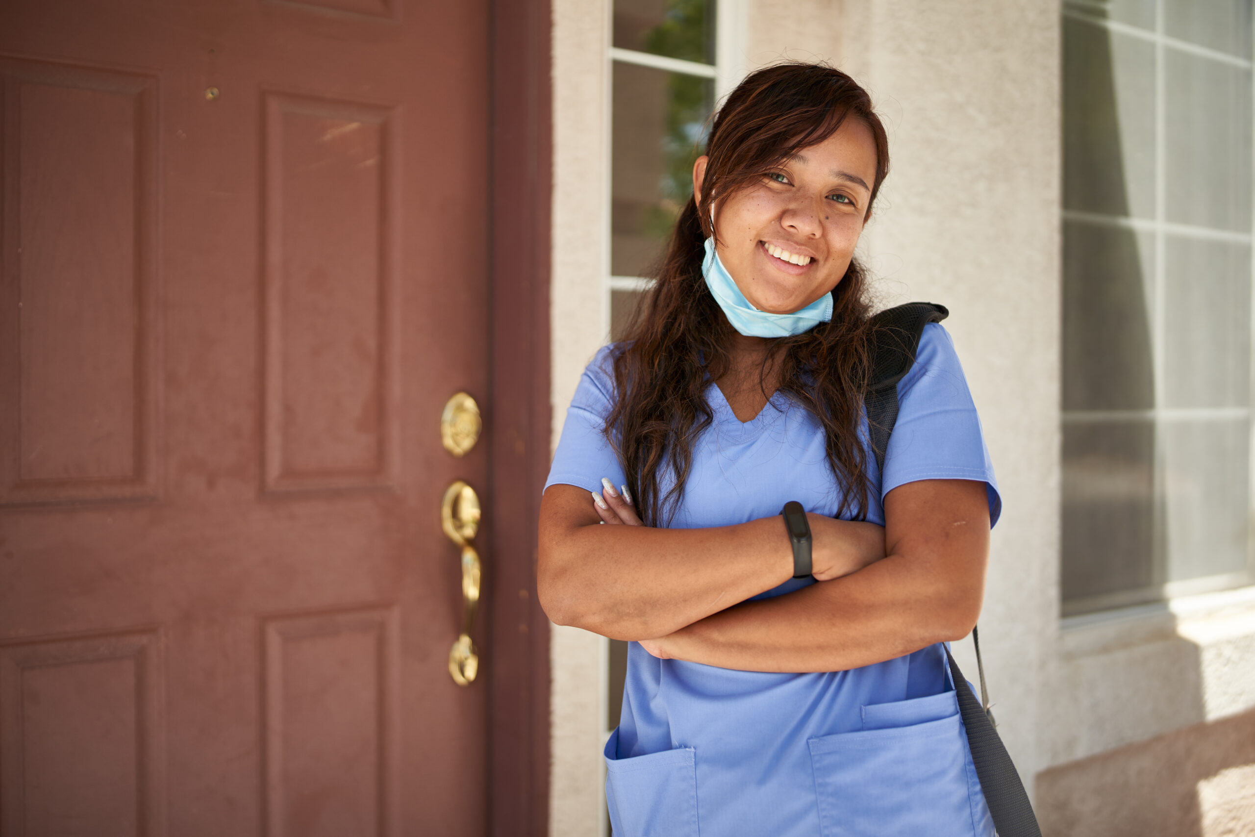 happy filipina nurse portrait in front of house