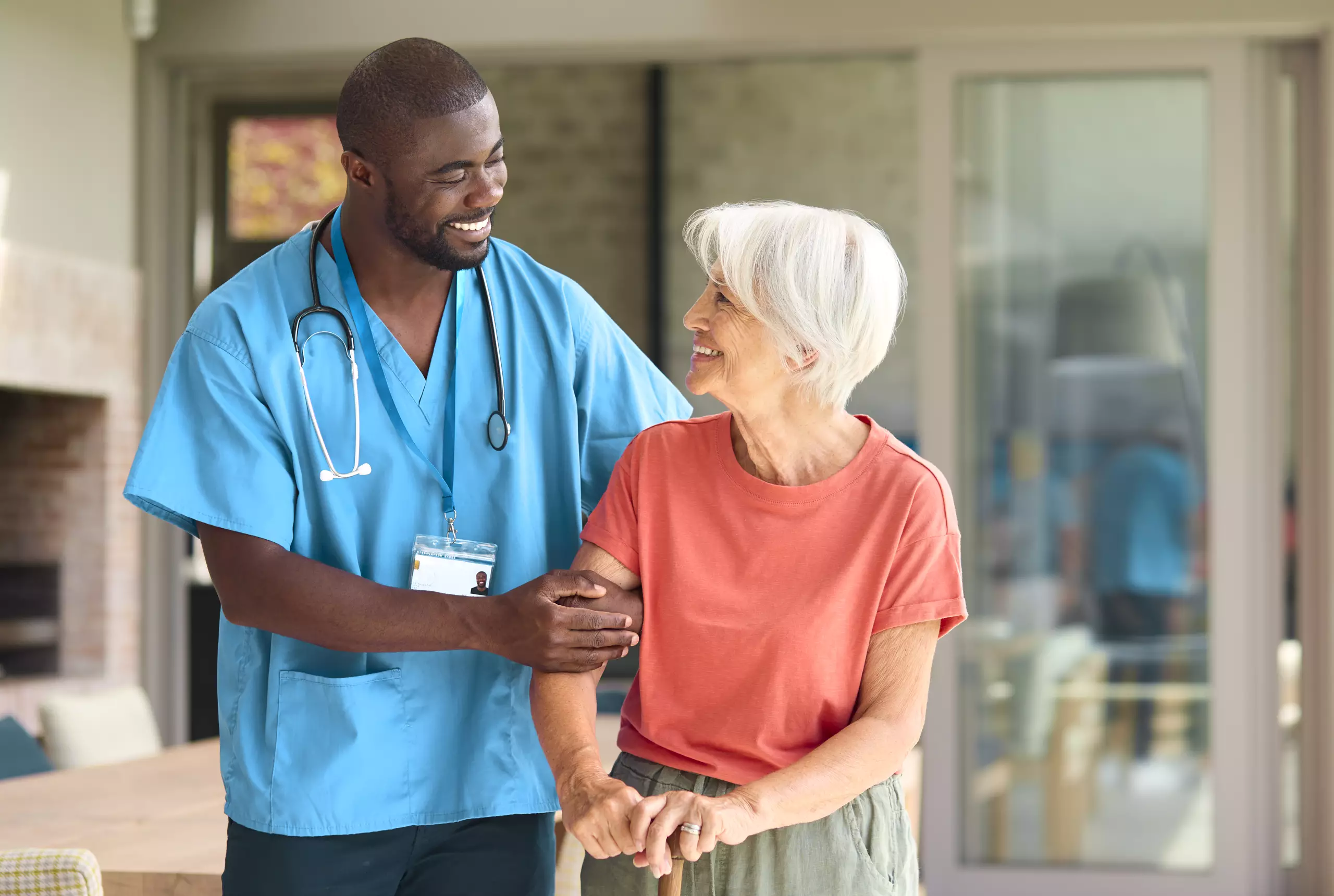 male-nurse-visiting-senior-woman-using-walking-sti-2026-01-05-06-26-53-utc